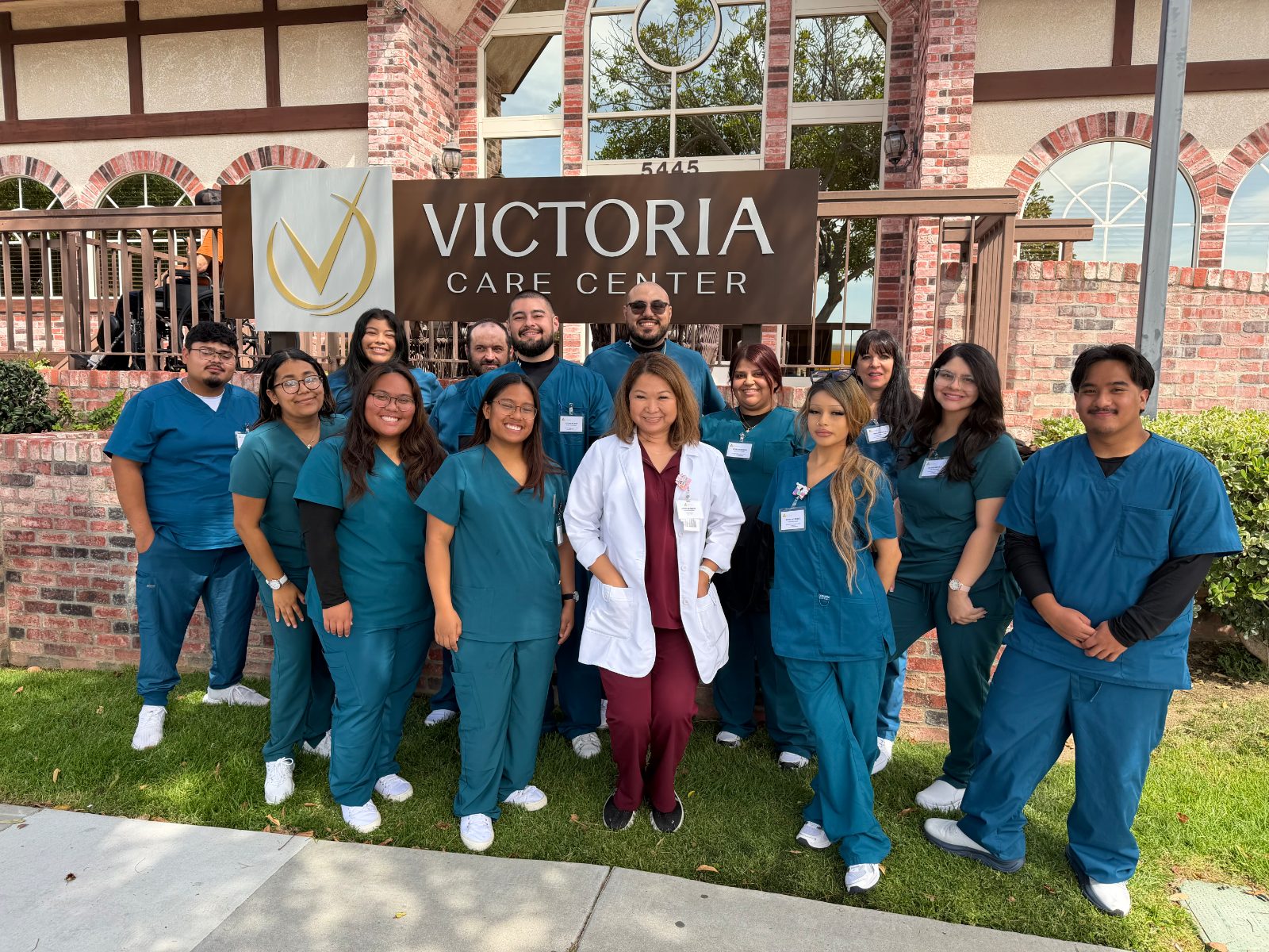 Trinity School of Nursing group in scrubs outside Victoria Care Center