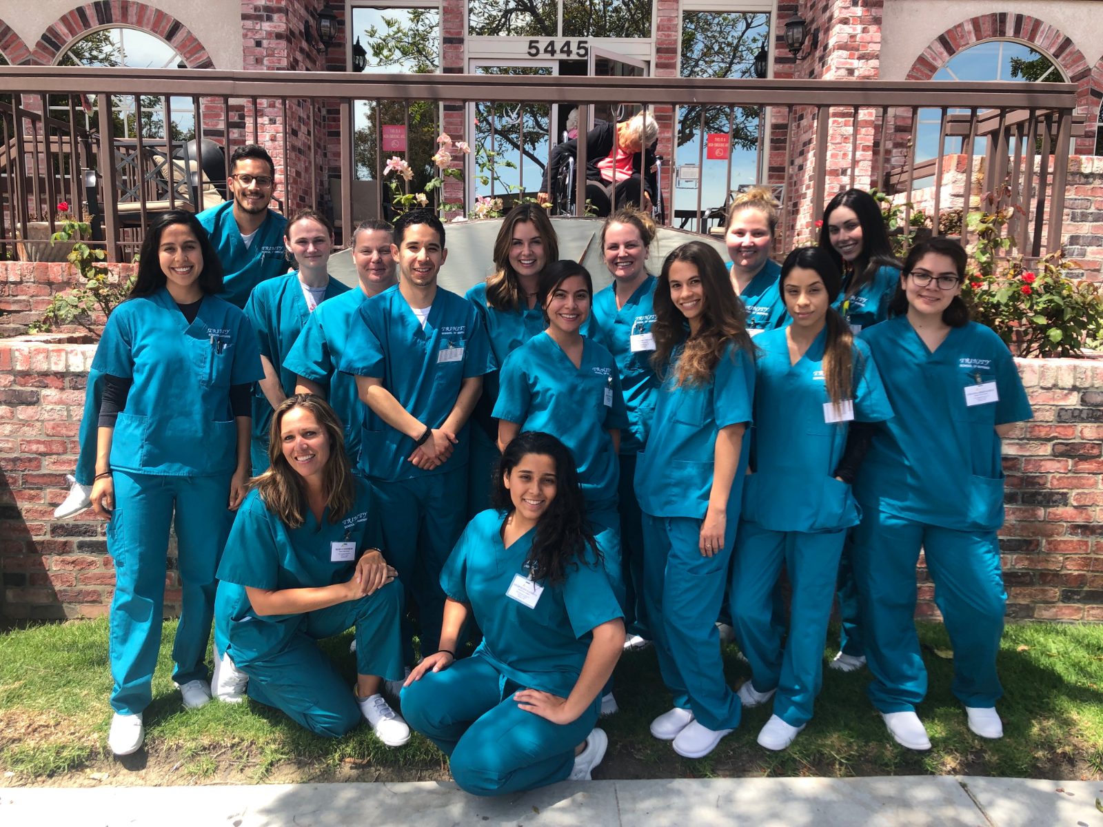 A Trinity group in blue scrubs gathered outdoors